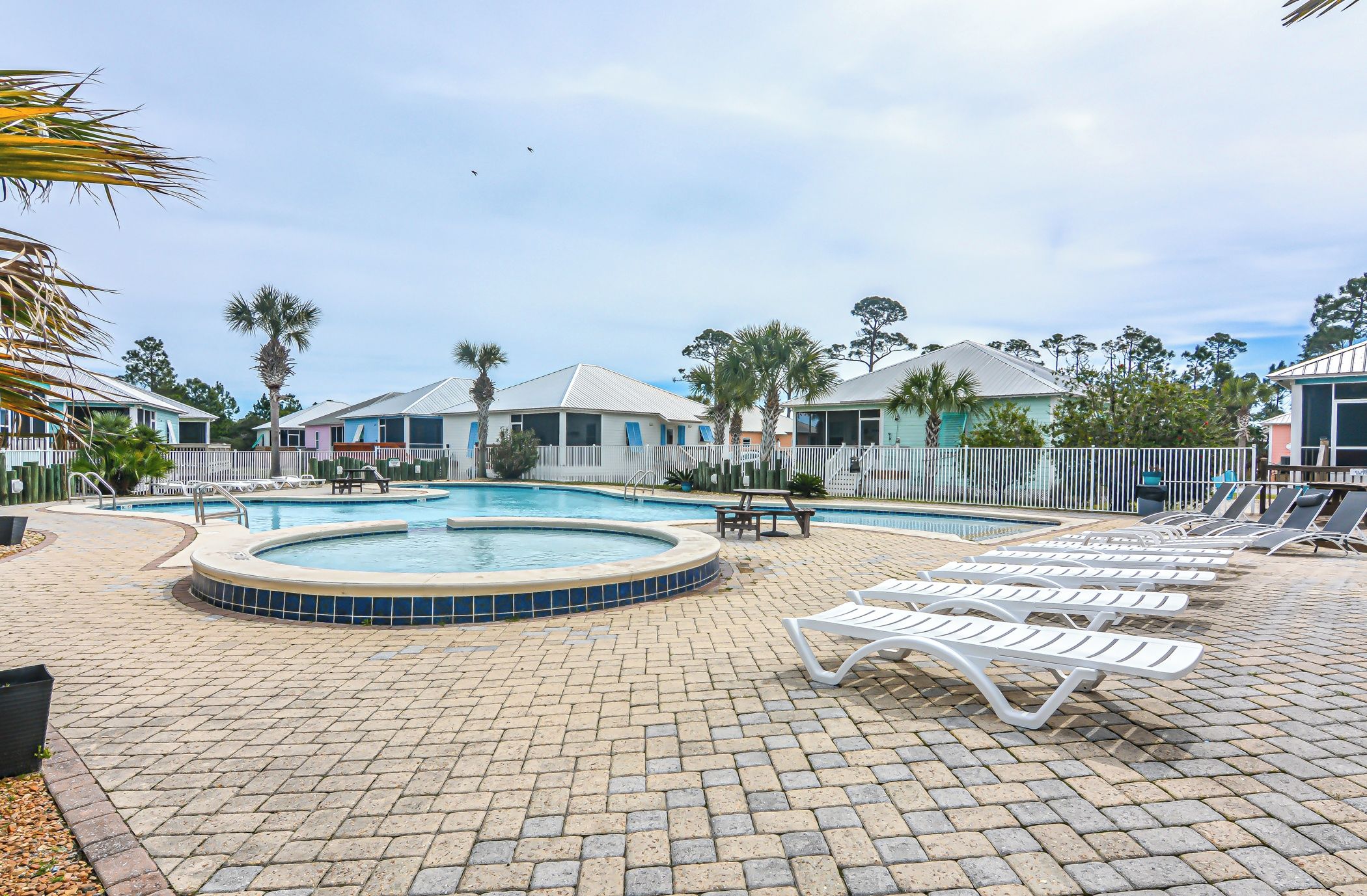 Un área de piscina con sillones reclinables y un jacuzzi.