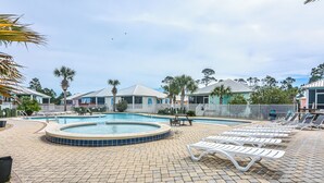 A pool area with lounge chairs and a hot tub. - 5002 Rookery 1/4 mile beach 2 pools (Gulf Shores)