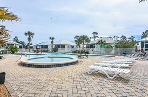 Un área de piscina con sillones reclinables y un jacuzzi.
