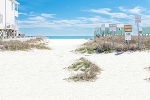 A sandy beach path leading to a building with multiple windows and a balcony. - 5003 Rookery 3 The Sea Pearl (Gulf Shores)