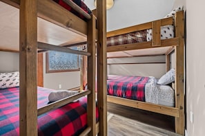 Une chambre de dortoir avec des lits superposés, une fenêtre et une vue sur l’extérieur.