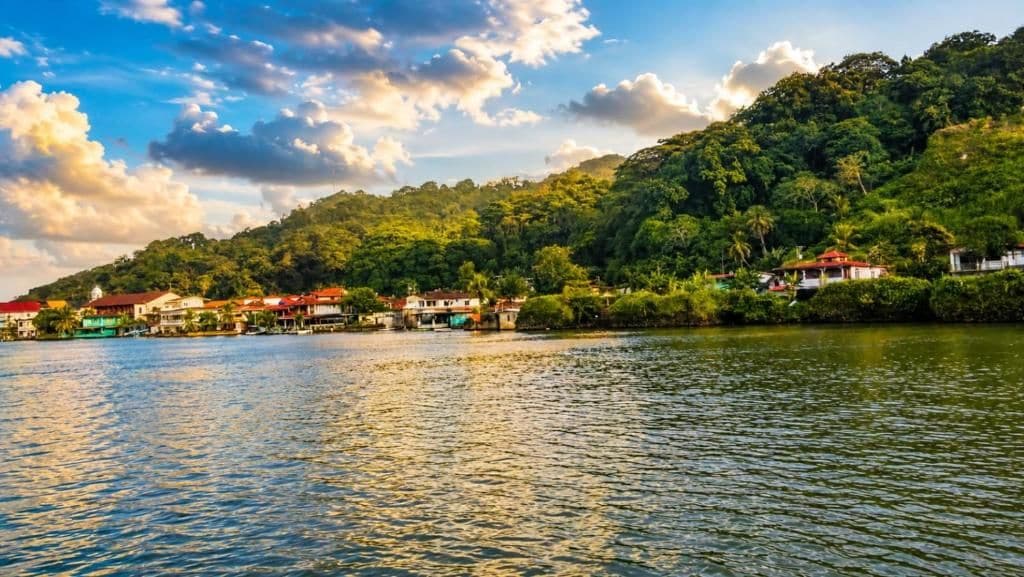 Um imóvel à beira-mar com vista para a água, uma colina e um conjunto de edifícios.