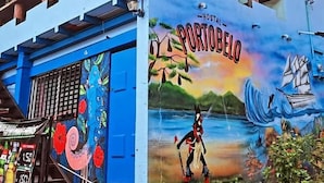 A building with a mural titled 'Hostal Portobelo' featuring a horse and a ship.