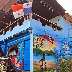 A building with a mural titled 'Hostal Portobelo' featuring a horse and a ship. - Hostal Portobelo (Portobelo)