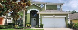 A two-story house with a garage, a front door with a wreath, and a mailbox. - Spacious 6-bedroom house just 10 minutes from Disney property (Kissimmee)
