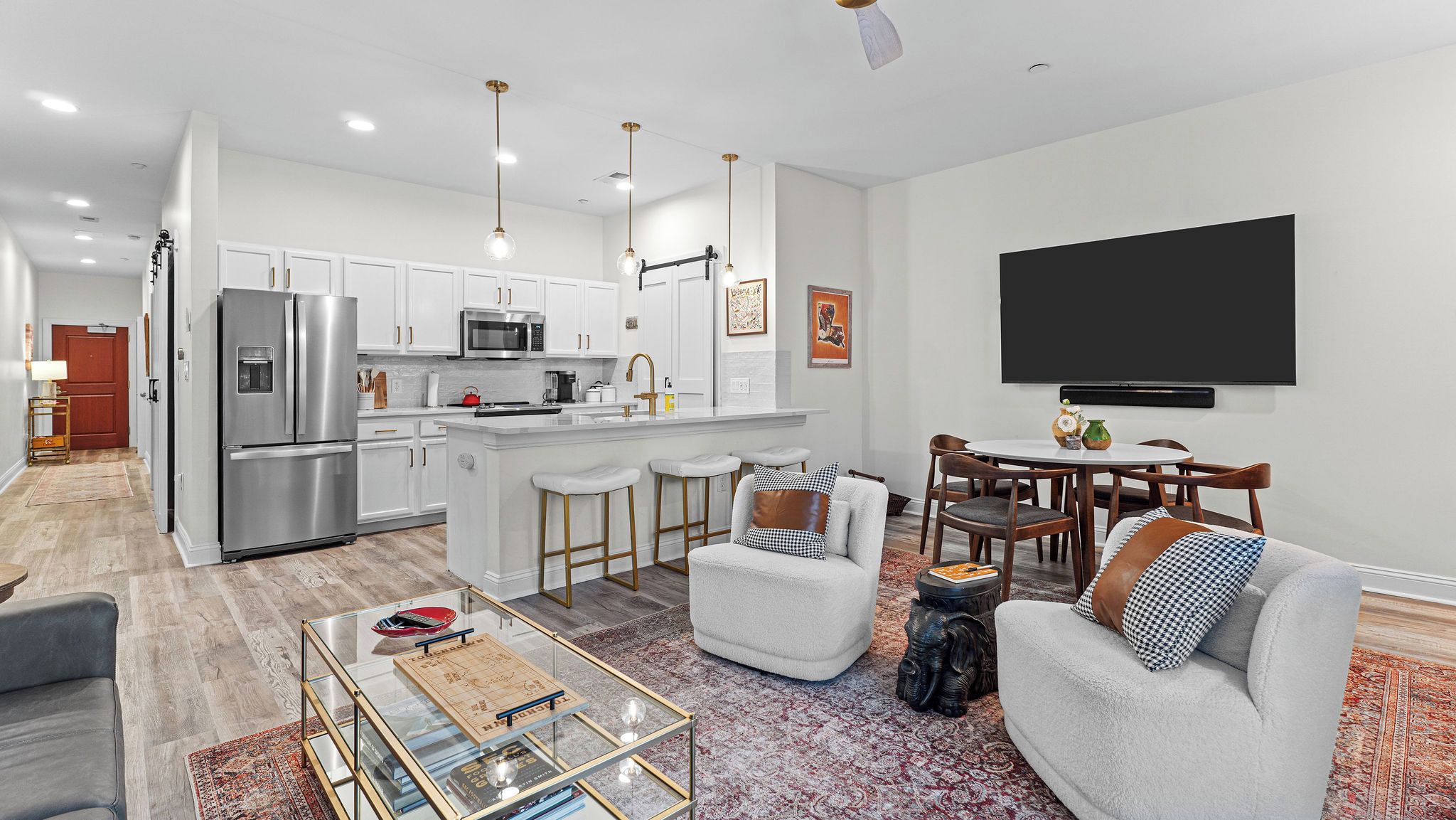 A modern kitchen with white cabinets, stainless steel appliances, and a central island.