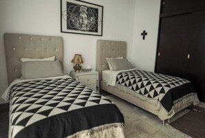 A bedroom with two beds, a nightstand, a lamp, and a framed picture on the wall. - spacious 5-bedroom house in peaceful Oaxaca de Juárez, Graden (Oaxaca de Juárez)