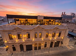 A hotel with a rooftop bar, multiple balconies, and classic architecture.