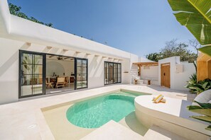 A modern outdoor pool area with a dining setup and a seating area. - Palmera Moana Uluwatu (Pecatu)
