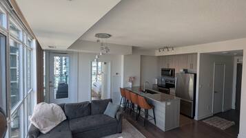 A modern kitchen with a central island, stainless steel appliances, and a dining area with bar stools.