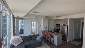 A modern kitchen with a central island, stainless steel appliances, and a dining area with bar stools.