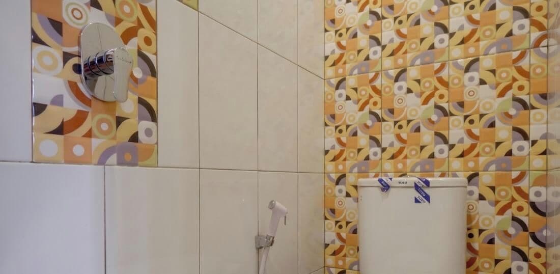 A bathroom with patterned tiles, a shower, and a toilet.