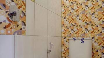 A bathroom with patterned tiles, a shower, and a toilet.