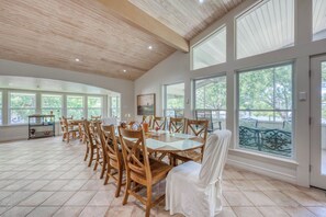 Un vaste espace dédié à la salle à manger, avec des meubles en bois et de grandes fenêtres.