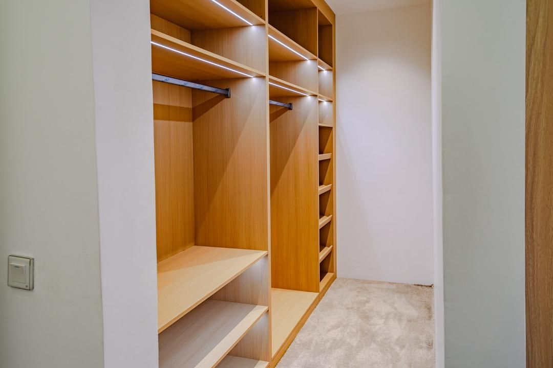 Un vestidor con estantes de madera y piso alfombrado.