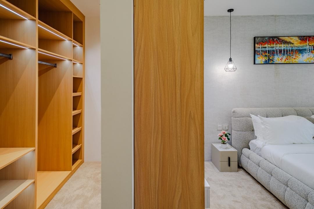 Un dormitorio con cama, mesita de noche y un cuadro en la pared.