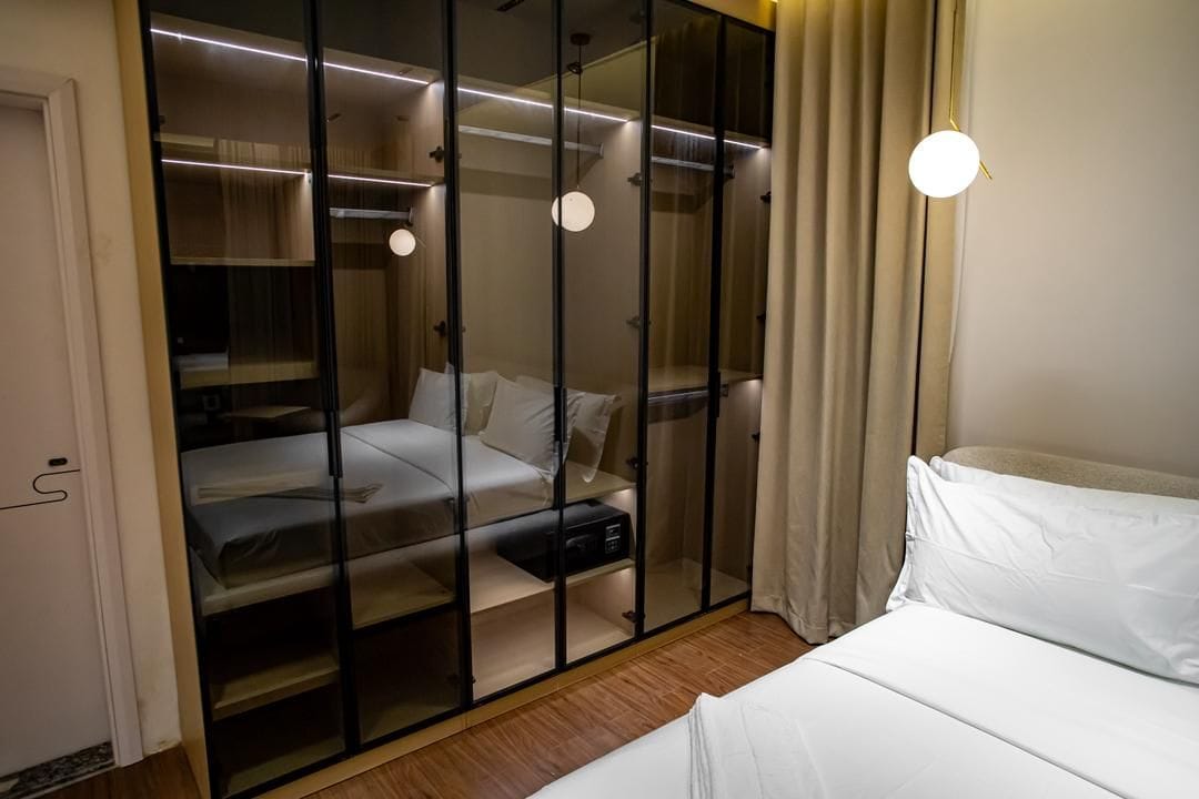 A bedroom with a bed, a wardrobe, and a bedside table.