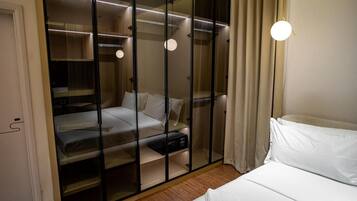 A bedroom with a bed, a wardrobe, and a bedside table.