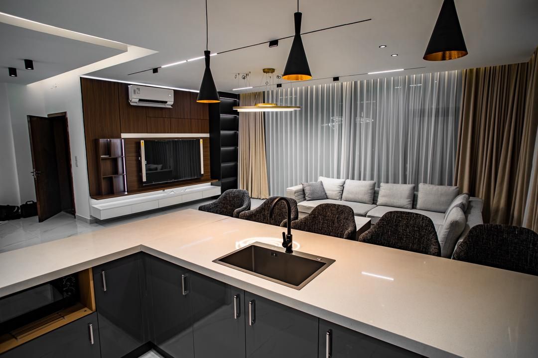 Una cocina moderna con una isla central, electrodomésticos integrados e iluminación colgante.