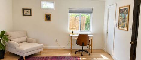 A room with a desk, chair, and a large window.