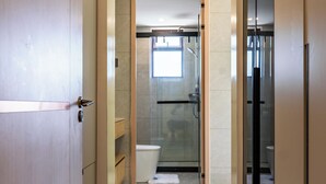 Ein modernes Badezimmer mit Duschkabine aus Glas, Toilette und Waschbecken.