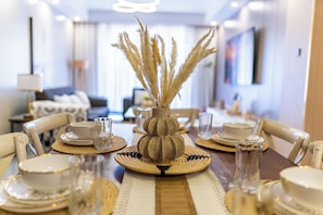 A dining table set with plates, glasses, and a decorative vase with dried plants. - 3-bedroom apartment in Westlands perfect Family friendly retreat, Pool, Gym, Wow (Nairobi)