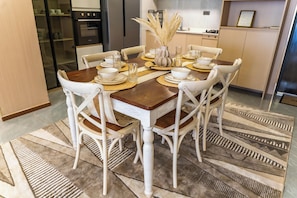 A dining area with a wooden table, white chairs, and a decorative centerpiece. - 3-bedroom apartment in Westlands perfect Family friendly retreat, Pool, Gym, Wow (Nairobi)