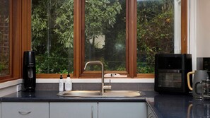 A kitchen with a sink, a coffee maker, and a microwave.