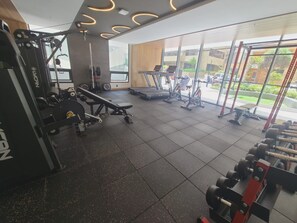 A gym with exercise equipment, a treadmill, and a view of the outside. - Luxurious studio apartment in Quito's financial district (Quito)