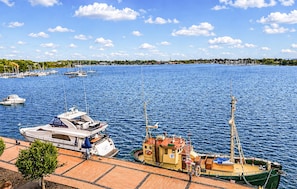 Ein Yachthafen mit vertäuten Booten, ein kleines Boot mit Kabine und ein klarer Himmel.