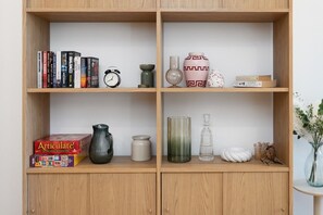 A beautifully organised timber display cabinet adds warmth and character to the home, with carefully selected décor creating a cosy and homely feel. - High-End 1BR with Enclosed Balcony Near ANU (Braddon)