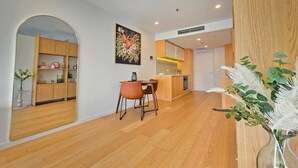 Een modern interieur met een eethoek, keuken en een grote spiegel die de ruimte weerspiegelt.