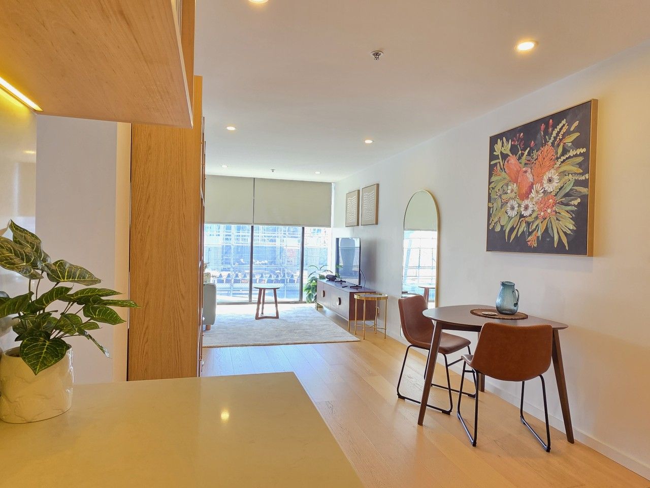 A modern living room with a dining area, large windows, and a view of the city.