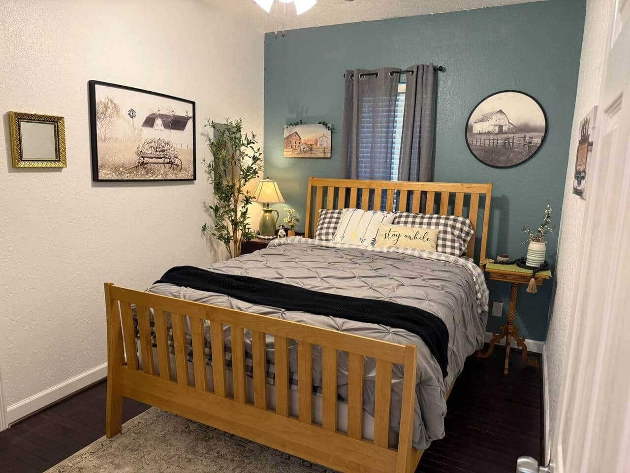 Un dormitorio con una cama de madera, una mesita de noche, una lámpara y decoración en la pared.