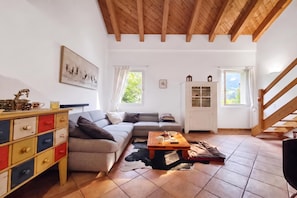 A living room with a wooden ceiling, a sofa, a coffee table, a cabinet, and a staircase. - Il Nido Di Gurin 1 - Ski hike and trail Bosco Gurin, Bosco Gurin, Switzerland (Bosco Gurin)