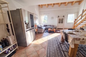 A compact living space with a kitchenette, a sofa, a dining table set for two, and a staircase. - Il Nido Di Gurin 2 -Ski hike and trail Bosco Gurin, Bosco Gurin, Switzerland (Bosco Gurin)