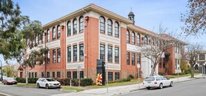 A two-story building with a brick facade, large windows, and a bell tower. - Devlin 103 - Stylish Geelong Apartment (Greater Geelong)