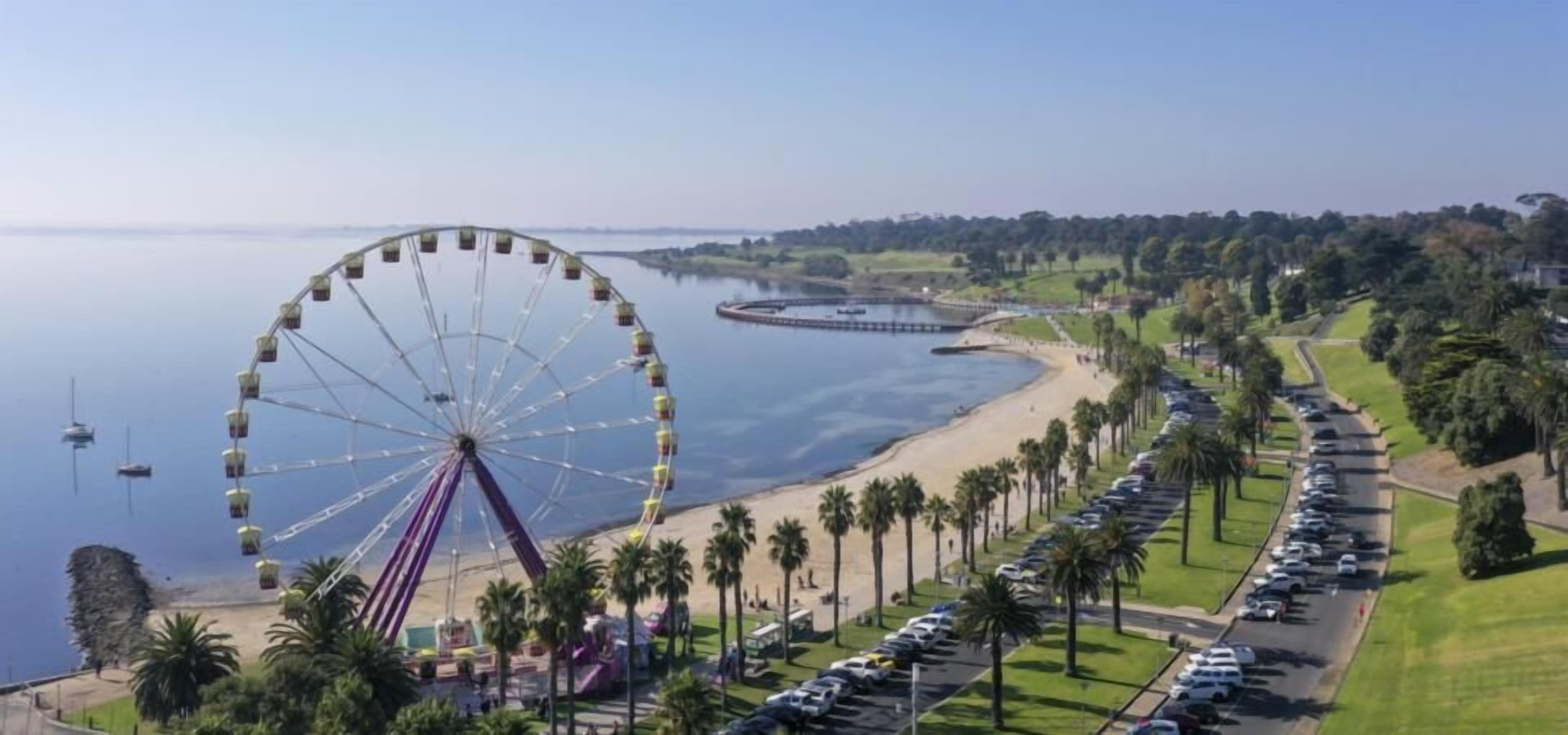 A Ferris wheel, a beach, and a parking lot.