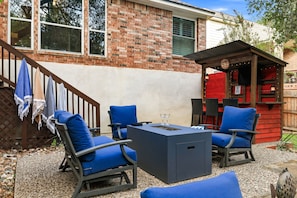 A patio with outdoor furniture, a brick wall, and a small red structure. - Walcoff - A Birdy Vacation Rental (Schertz)