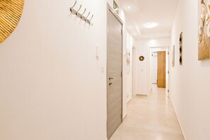 A hallway with a coat rack, a door, and a wall-mounted light fixture. - Comfort & Modern Sea-View 3 bdr Apart, Saint Paul's Bay, Malta (Saint Paul's Bay)