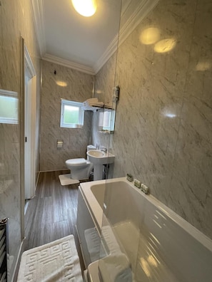 A bathroom with a bathtub, toilet, and sink, all in white.