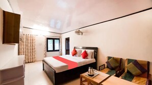 A bedroom with a bed, a sofa, a table, and a wardrobe. - Goroomgo Blue Moon Bhimtal (Nainital)