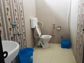 Un baño pequeño con inodoro, lavamanos y ducha.