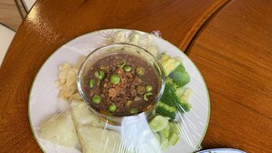 Un tavolo imbandito con tre piatti: una zuppa con piselli, un'insalata con verdure miste e un altro piatto con verdure verdi.