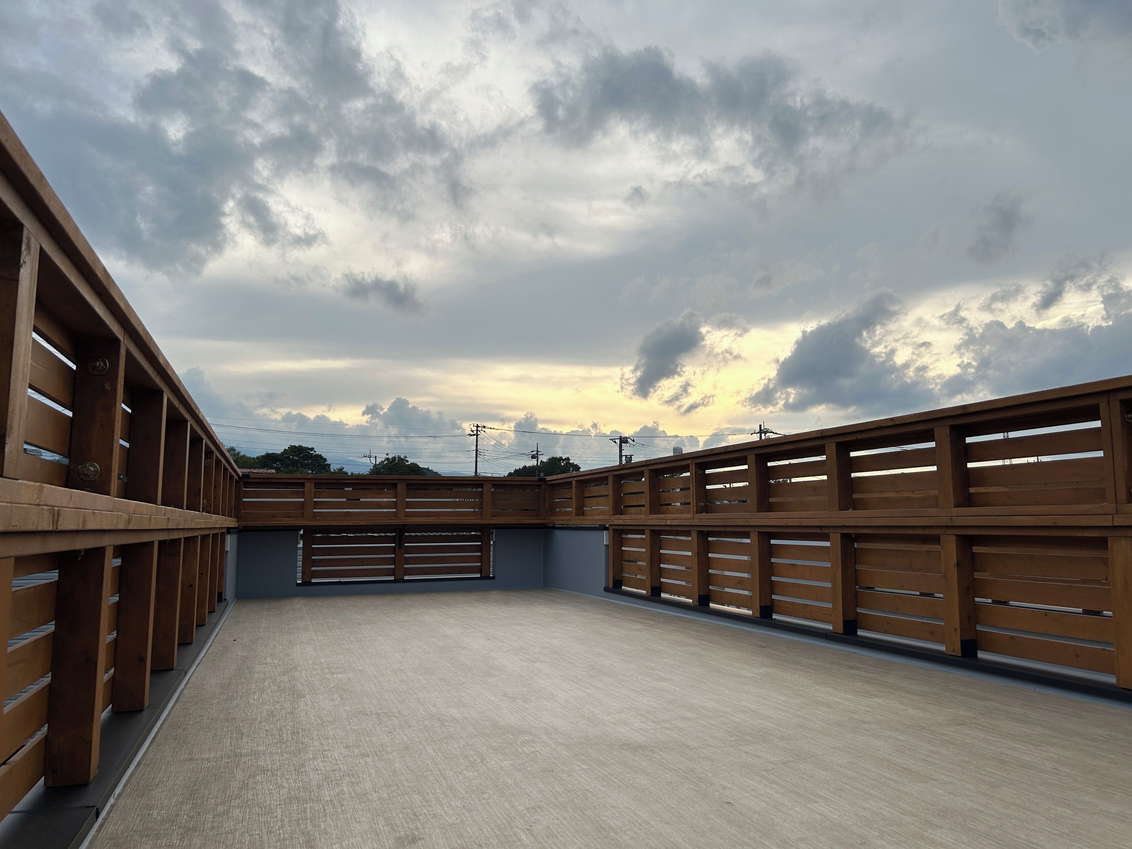 A spacious indoor area with a concrete floor and wooden railings.