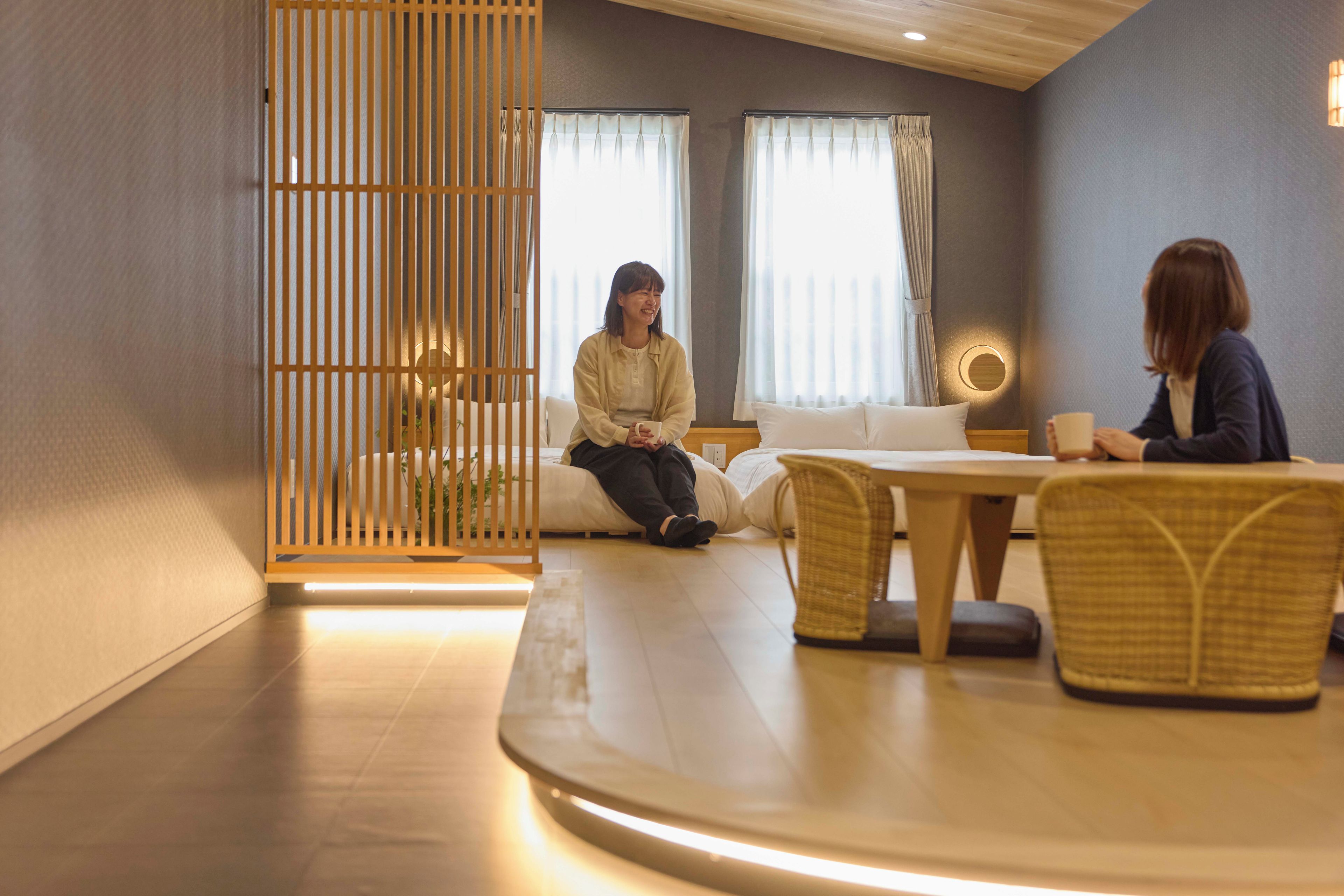 A modern interior with a sofa, a dining table, and a wooden partition.