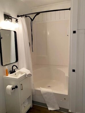 Ein Badezimmer mit Waschbecken, Spiegel und Duschvorhang.