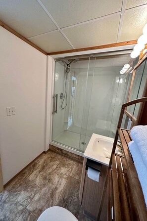 Ein kleines Badezimmer mit Duschkabine, Waschbecken und Toilette.