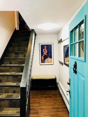 A staircase with a wooden handrail and a wall-mounted picture.