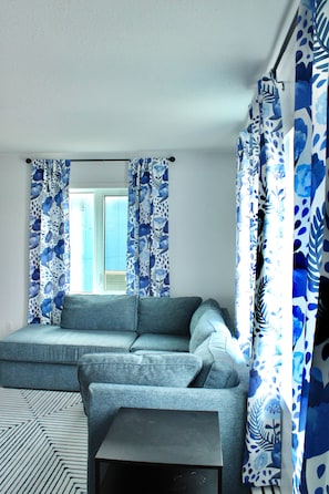 A modern living room with a sectional sofa, a small table, and a patterned rug.